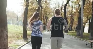 年轻人和女孩在锻炼。 健身夫妇一起在阳光公园跑步。 男子和妇女一起参加体育训练